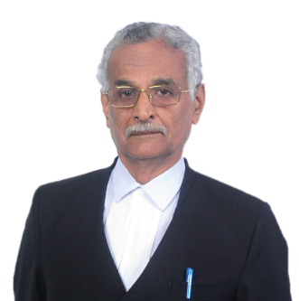 Older man with gray hair and glasses wearing a black suit jacket and white shirt, with a pen in his jacket pocket.